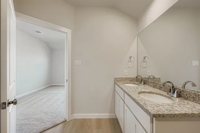 a bathroom with a granite countertop sink and a mirror