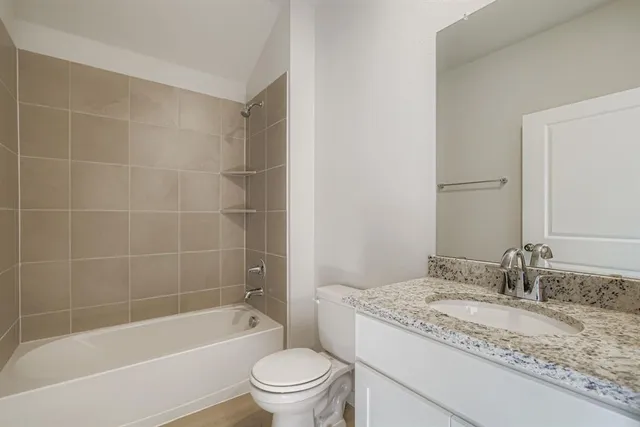 a bathroom with a granite countertop sink a toilet and bathtub