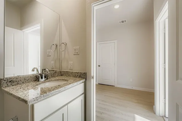 a bathroom with a granite countertop sink and a mirror