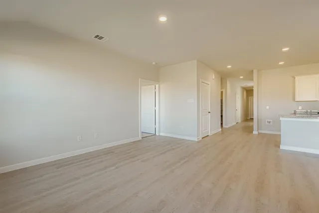 a view of a big room with wooden cabinet and windows