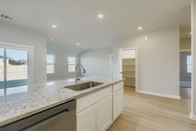 a kitchen with granite countertop a sink and a wooden floor