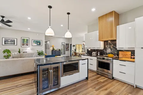 a kitchen with stainless steel appliances granite countertop a stove a sink and a refrigerator
