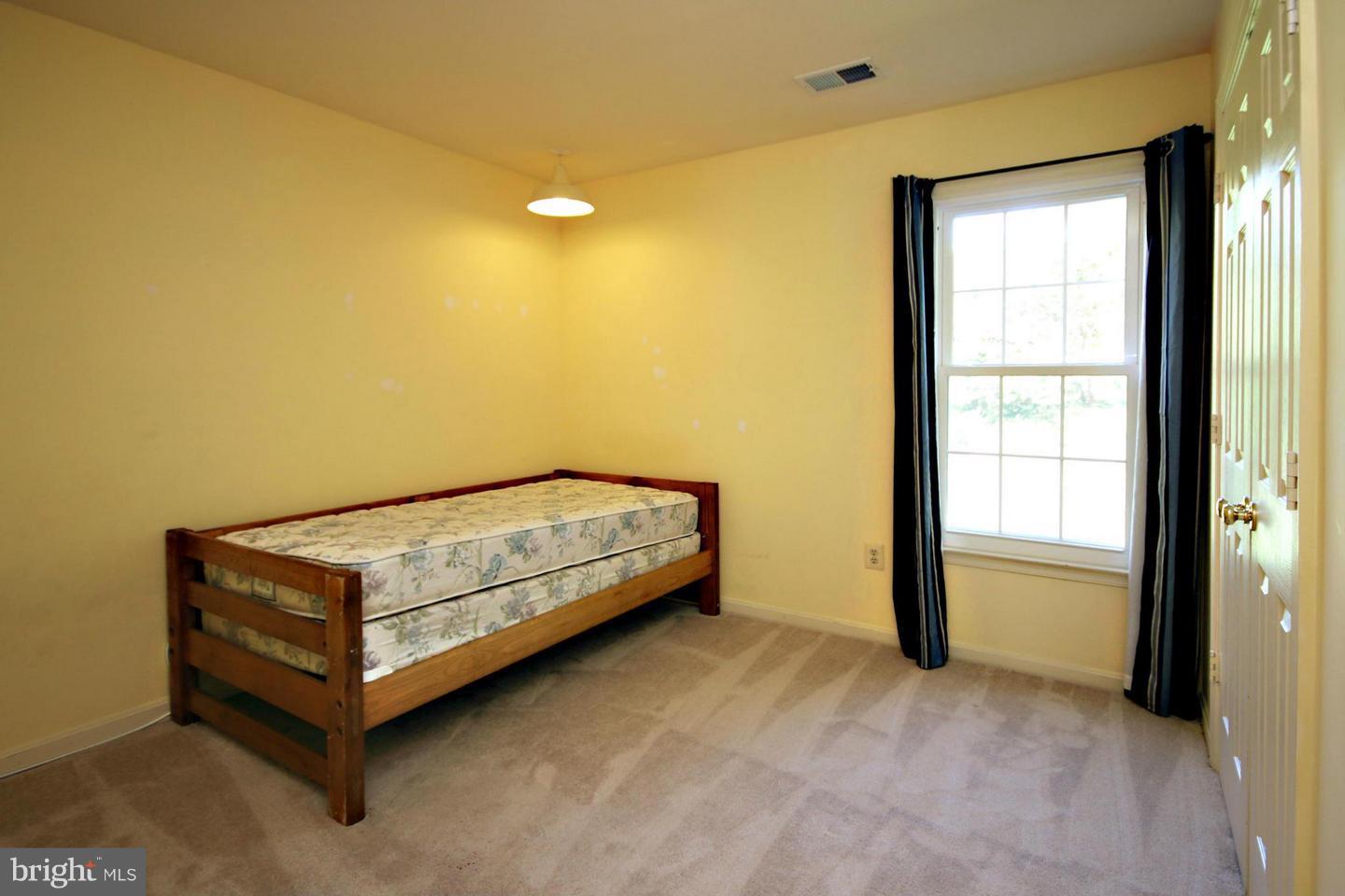 14416 Old Stage Road Bowie, MD 20720 - Photo 14 of 24 a bed sitting in a room next to a window