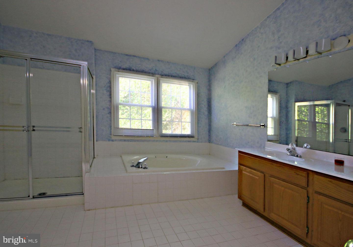 14416 Old Stage Road Bowie, MD 20720 - Photo 19 of 24 a bathroom with a bathtub sink and mirror