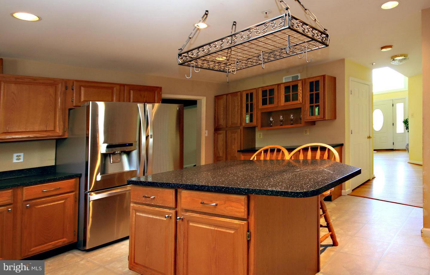 14416 Old Stage Road Bowie, MD 20720 - Photo 3 of 24 a kitchen with stainless steel appliances granite countertop a sink a refrigerator and wooden cabinets