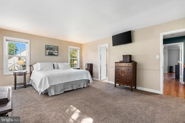 a spacious bedroom with a bed and a tv