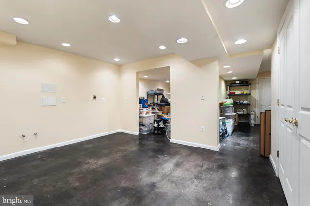 an empty room with closet and a view of living room