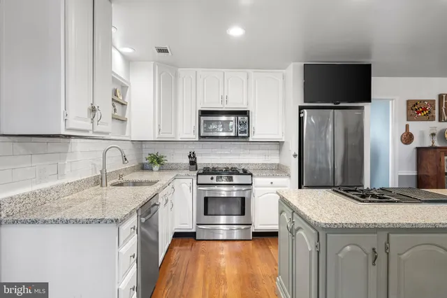 a kitchen with granite countertop a sink stove and refrigerator