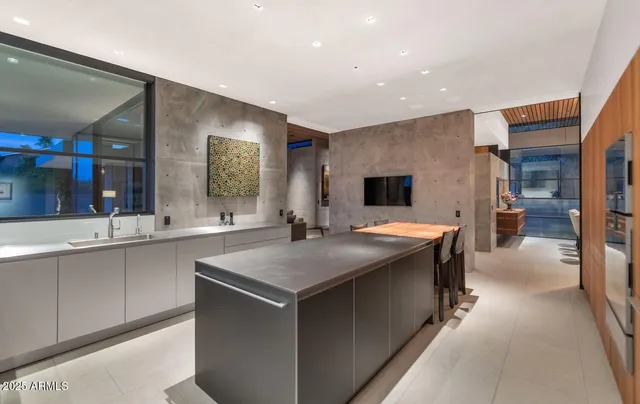 a kitchen with stainless steel appliances granite countertop a table chairs sink and cabinets