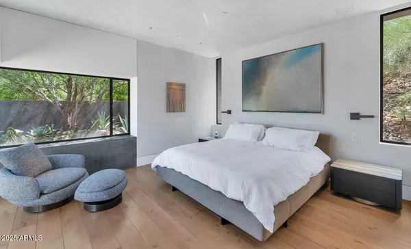 a bedroom with a bed and a painting on the wall