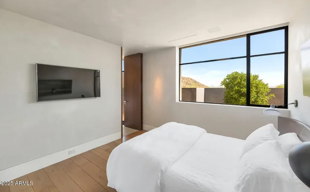 a bedroom with a bed and wooden floor