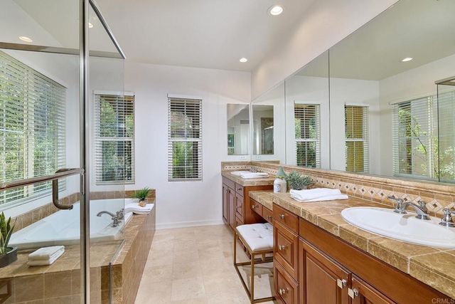 a bathroom with a granite countertop sink and a large mirror