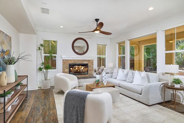 a living room with furniture a clock and a large window