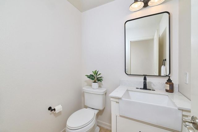 a bathroom with a sink mirror vanity and toilet