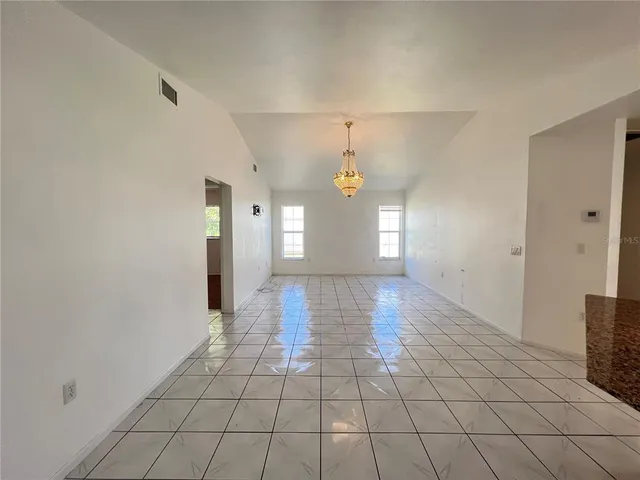a view of a kitchen with kitchen island granite countertop stainless steel appliances stove top oven and cabinets