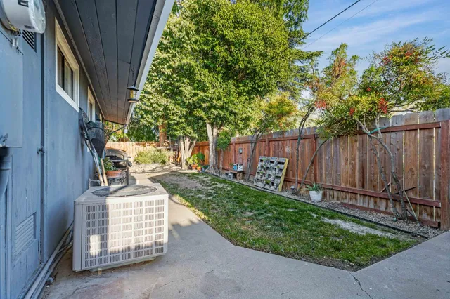 a view of backyard with table and chairs and wooden fence