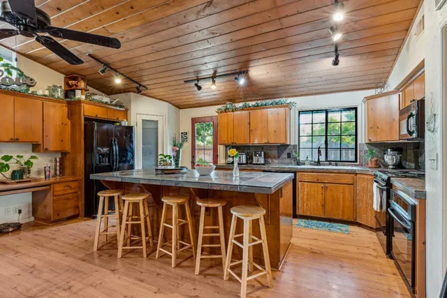 a kitchen with stainless steel appliances granite countertop a stove a sink dishwasher and cabinets with wooden floor