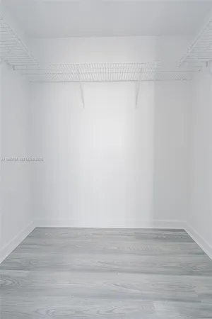 an empty room with wooden floor and window