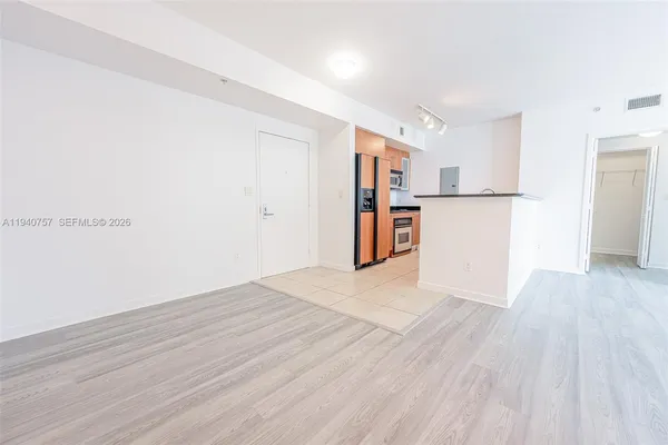 a hallway with granite countertop white cabinets and stainless steel appliances