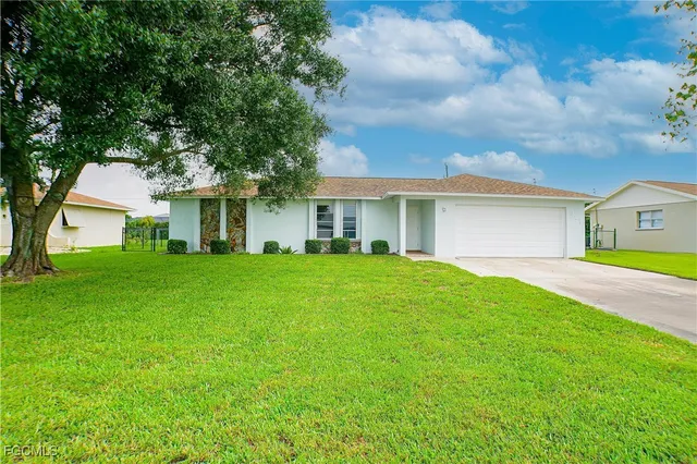 a front view of a house with yard and green space
