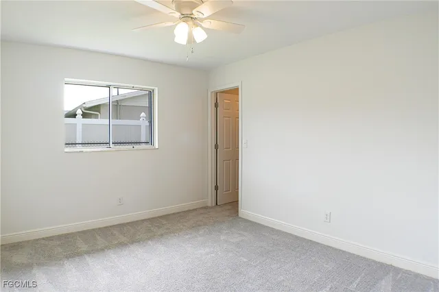 an empty room with a chandelier fan
