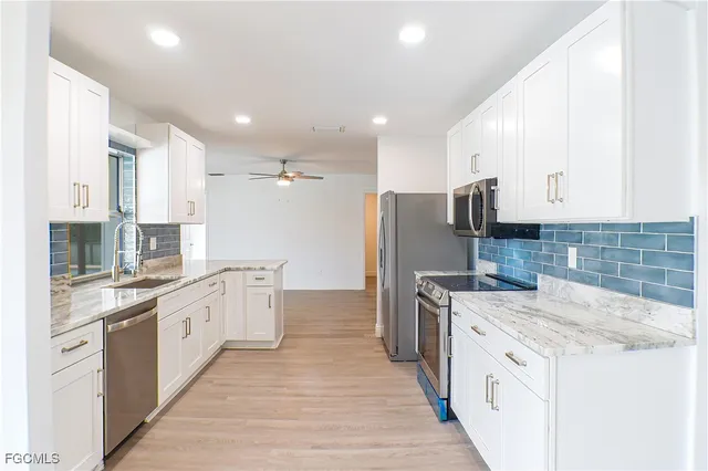 a kitchen with stainless steel appliances a sink stove refrigerator and cabinets
