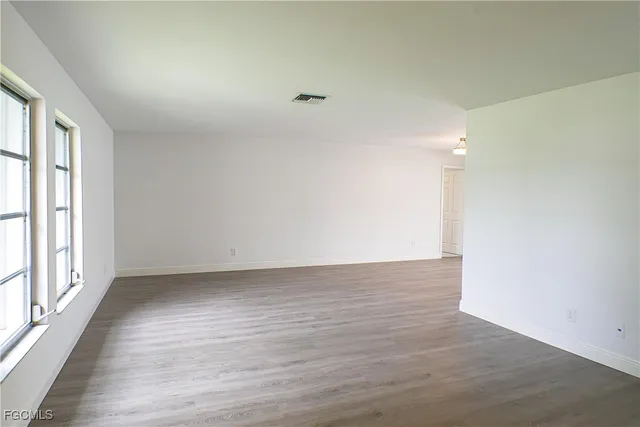 wooden floor in an empty room with a window