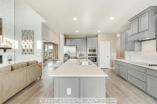 a living room with stainless steel appliances kitchen island granite countertop a refrigerator a sink dishwasher with a dining table and chairs