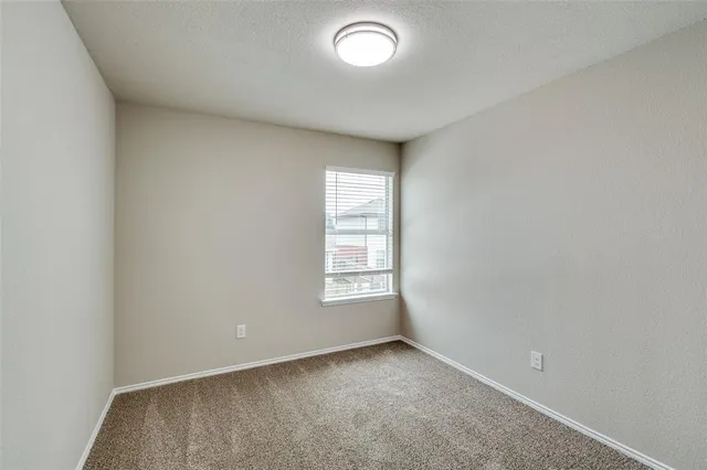 an empty room with a window and ceiling fan