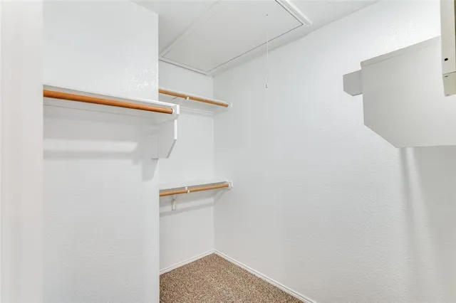 a view of walk in closet with empty racks