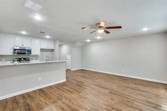 a living room with furniture a flat screen tv and kitchen view