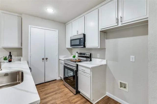 a view of a sink and dishwasher with wooden floor