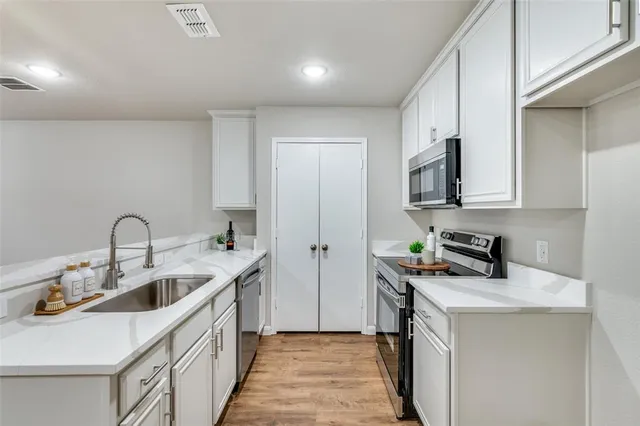 a kitchen with a sink a stove and cabinets