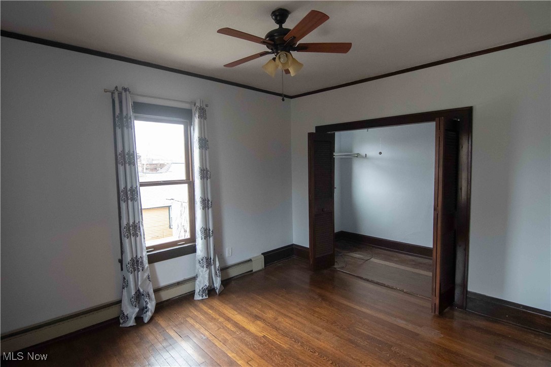 1905 Fulton Road, Unit 3A Cleveland, OH 44113 - Photo 7 of 34 Empty room featuring ornamental molding, baseboards, wood finished floors, and ceiling fan