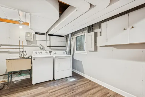 a utility room with cabinets washer and dryer