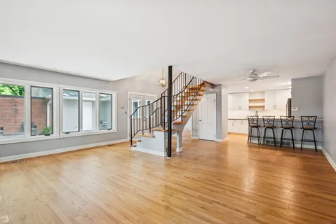 a view of an empty room with wooden floor and a floor to ceiling window