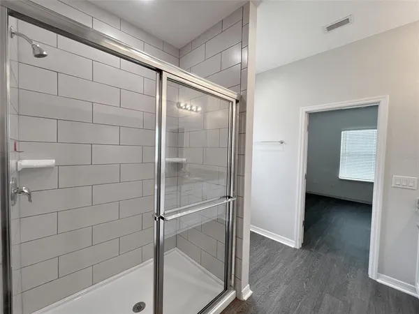a bathroom with a shower and a glass door