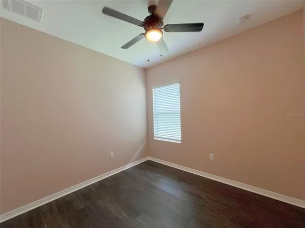 an empty room with a window and a fan