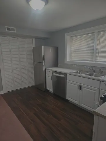 a kitchen with a sink cabinets and wooden floor