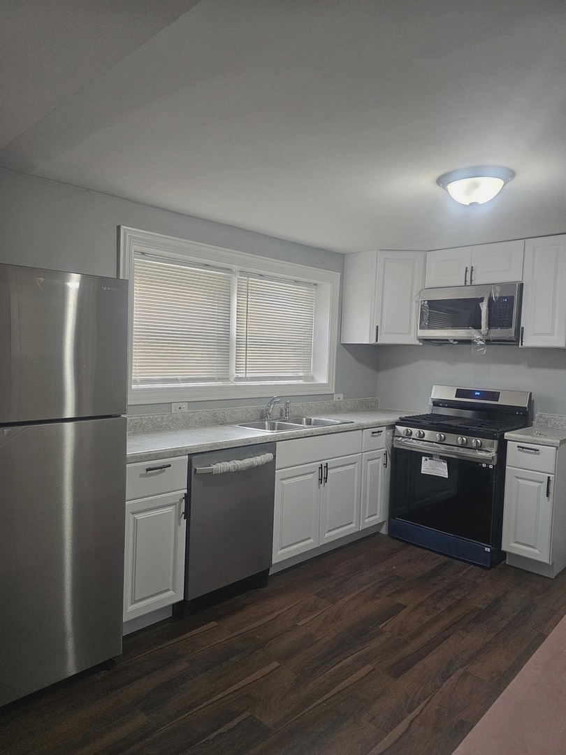 2441 West 46th Place, Unit 1 Chicago, IL 60632 - Photo 3 of 8 a kitchen with granite countertop a refrigerator stove top oven and sink