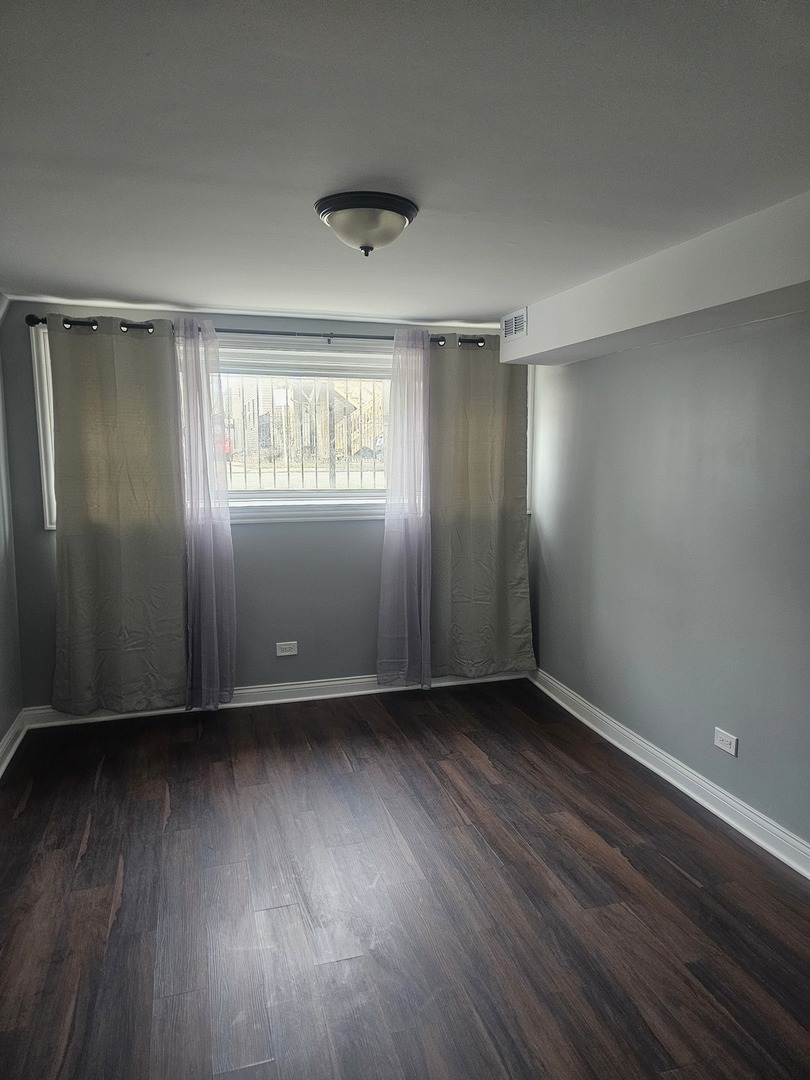 2441 West 46th Place, Unit 1 Chicago, IL 60632 - Photo 4 of 8 an empty room with wooden floor and windows