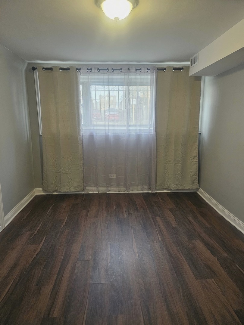 2441 West 46th Place, Unit 1 Chicago, IL 60632 - Photo 5 of 8 an empty room with wooden floor and windows