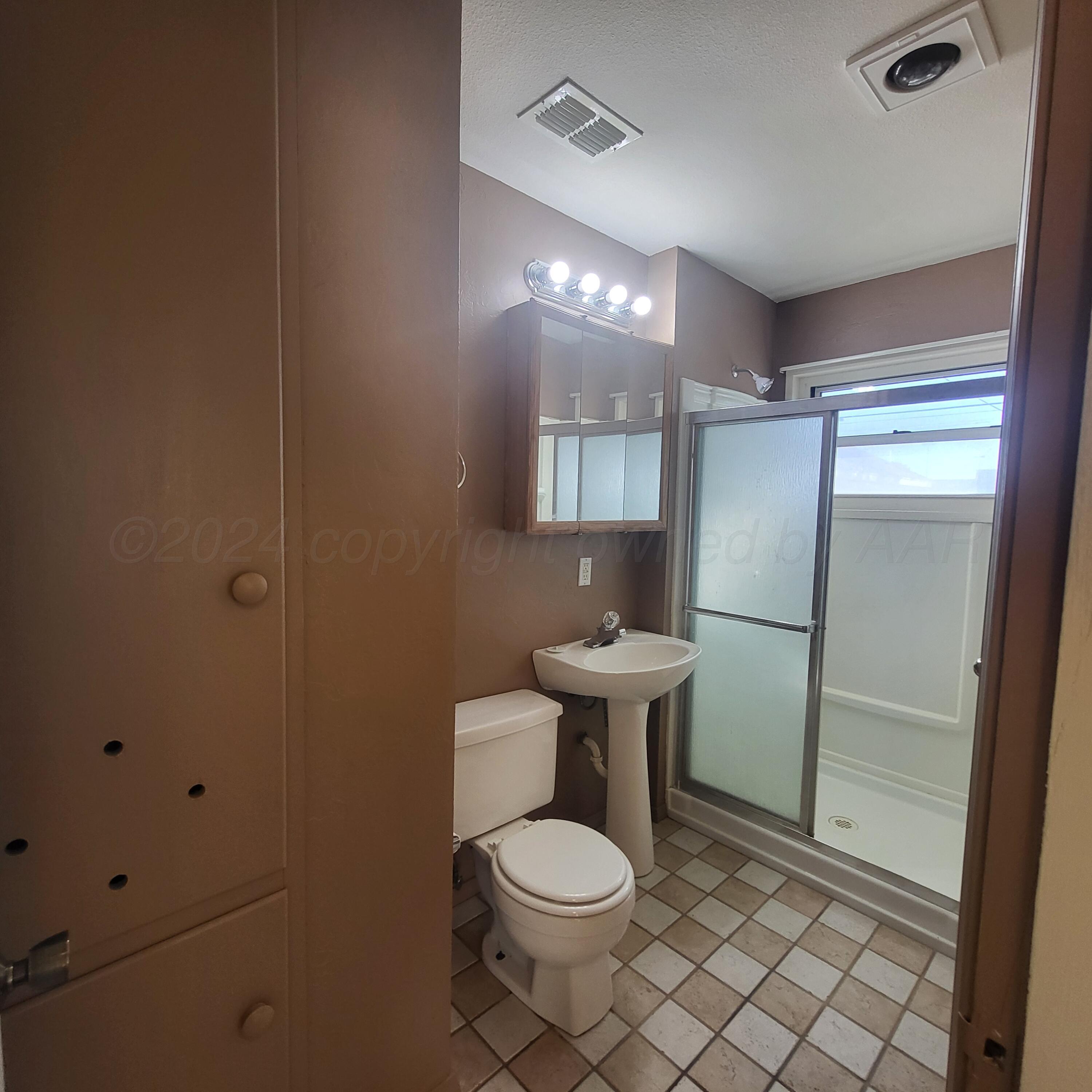 4619 South Hughes Street Amarillo, TX 79110 - Photo 9 of 15 a bathroom with a toilet a sink and mirror