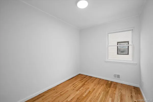 a view of a room with wooden floor and white walls