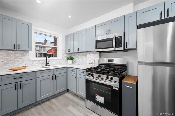 a kitchen with cabinets stainless steel appliances and a sink
