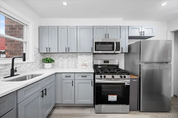 a kitchen with cabinets stainless steel appliances and a sink