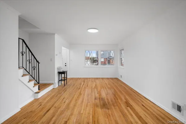 a view of empty room with wooden floor