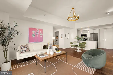 a living room with furniture a chandelier and a table