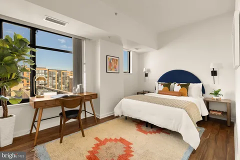 a bedroom with a bed and a potted plant