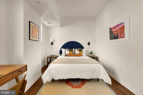 a bedroom with a bed and a painting on the wall